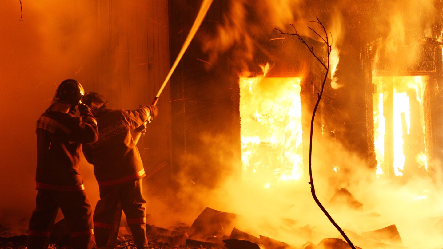 two firefighters fighting structure fire