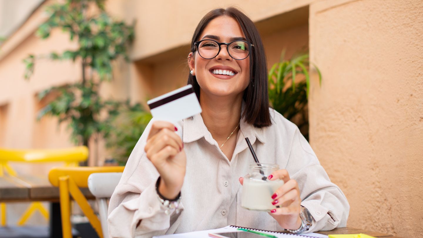 Woman at outdoor restaurant holding a credit card