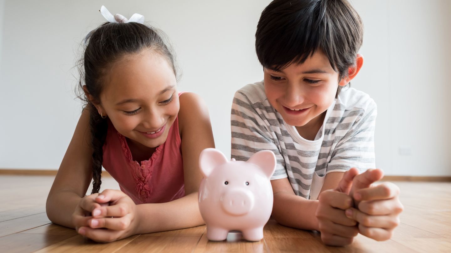 Two kids looking at piggy bank