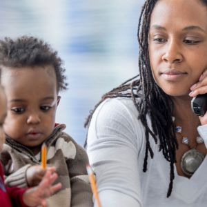 Mom on phone with two children